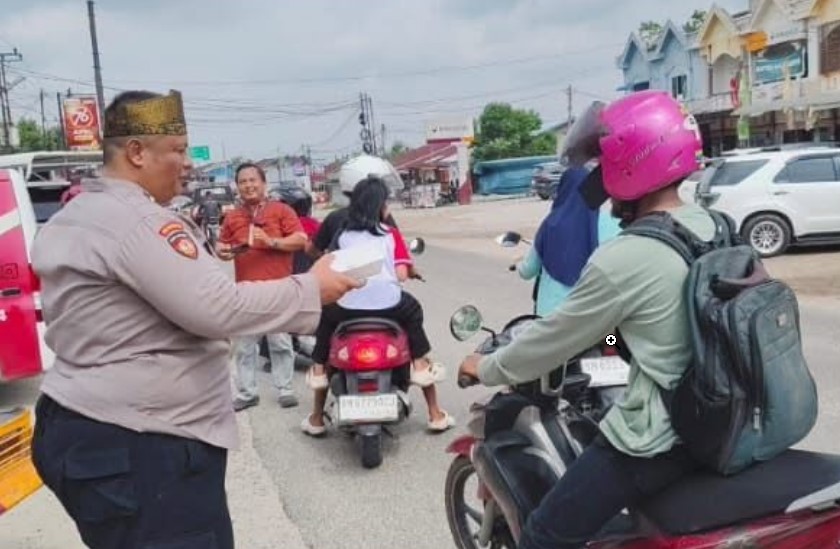 Babada Foundation bersama Polsek Tenayan Raya menggelar Jumat Berkah dengan membagikan makanan dan roti kepada pengendara yang memakai helm.